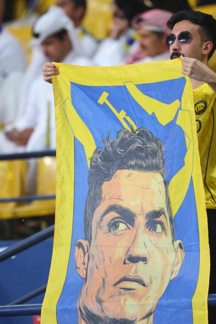A fan holds a banner with picture of Nassr's Portuguese forward #07 Cristiano Ronaldo before the start of the 2026 AFC Champions League Two final football match between Al-Nassr and Gamba Osaka at the Al-Awwal Park Stadium in Riyadh on May 16, 2026. (Photo by Fayez NURELDINE / AFP)