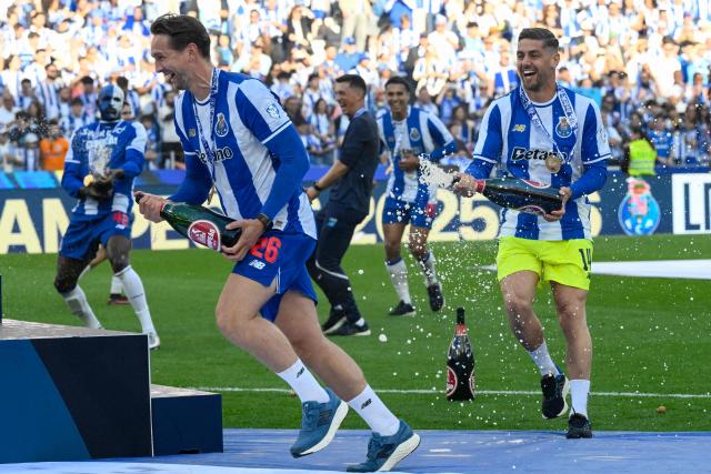 FC Porto's Dutch forward #26 Luuk De Jong (L) and FC Porto's Portuguese goalkeeper #14 Claudio Ramos spray champagne during celebrations for winning the Portuguese League trophy after their Portuguese League football match between FC Porto and CD Santa Clara at the Dragao stadium in Porto on May 16, 2026. (Photo by Miguel RIOPA / AFP)