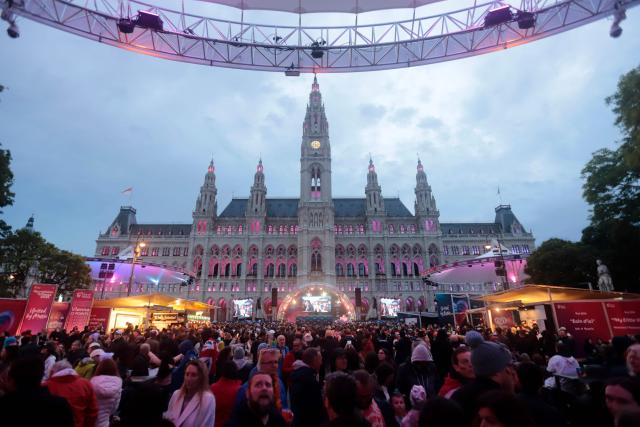 Spectators and fans walk at the fan area prior to the final of the Eurovision Song Contest 2026 (ESC) outside the City Hall in Vienna, Austria on May 16, 2026. (Photo by Alex HALADA / AFP)
