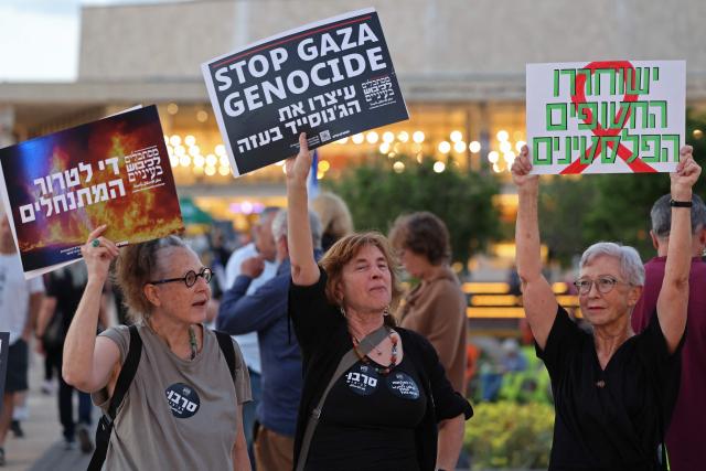 Israeli left-wing activists hold placards during a demonstration against the country's ruling government and the ongoing war in the Middle East at the HaBima Square in Tel Aviv on May 16, 2026. (Photo by Jack GUEZ / AFP)