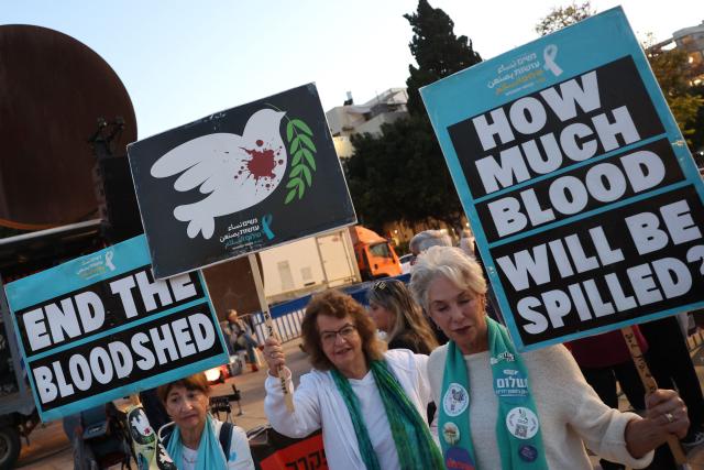 Israeli left-wing activists hold placards during a demonstration against the country's ruling government and the ongoing war in the Middle East at the HaBima Square in Tel Aviv on May 16, 2026. (Photo by Jack GUEZ / AFP)