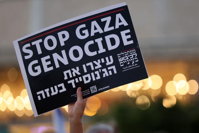 An Israeli left-wing activist holds a placard during a demonstration against the country's ruling government and the ongoing war in the Middle East at the HaBima Square in Tel Aviv on May 16, 2026. (Photo by Jack GUEZ / AFP)