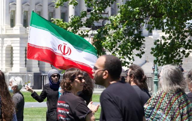 A person holds an Iranian flag as demonstrators gather near the US Capitol while participating in a Nakba solidarity bike ride from Dupont Circle to the US Capitol in Washington, DC, on May 16, 2026, marking the 78th anniversary of the Nakba. (Photo by Amid FARAHI / AFP)