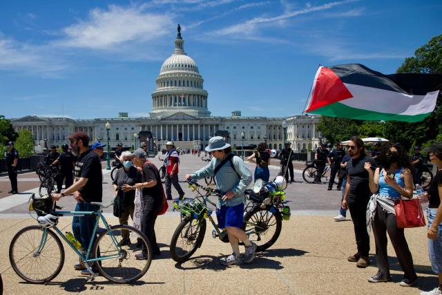 A demonstrator carries a Palestinian flag as people gather near the US Capitol while participating in a Nakba solidarity bike ride from Dupont Circle to the US Capitol in Washington, DC, on May 16, 2026, marking the 78th anniversary of the Nakba. (Photo by Amid FARAHI / AFP)
