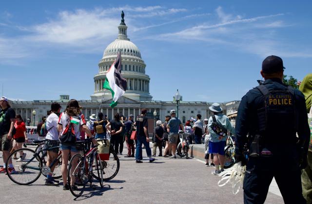 A US Capitol police officer watches demonstrators gather near the US Capitol while participating in a Nakba solidarity bike ride from Dupont Circle to the US Capitol in Washington, DC, on May 16, 2026, marking the 78th anniversary of the Nakba. (Photo by Amid FARAHI / AFP)