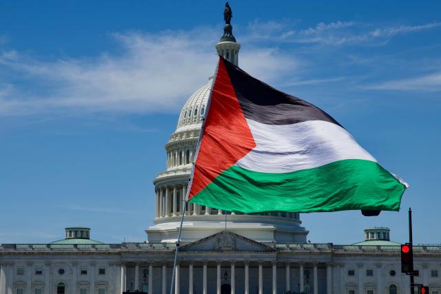 A demonstrator carries a Palestinian flag as people gather near the US Capitol while participating in a Nakba solidarity bike ride from Dupont Circle to the US Capitol in Washington, DC, on May 16, 2026, marking the 78th anniversary of the Nakba. (Photo by Amid FARAHI / AFP)
