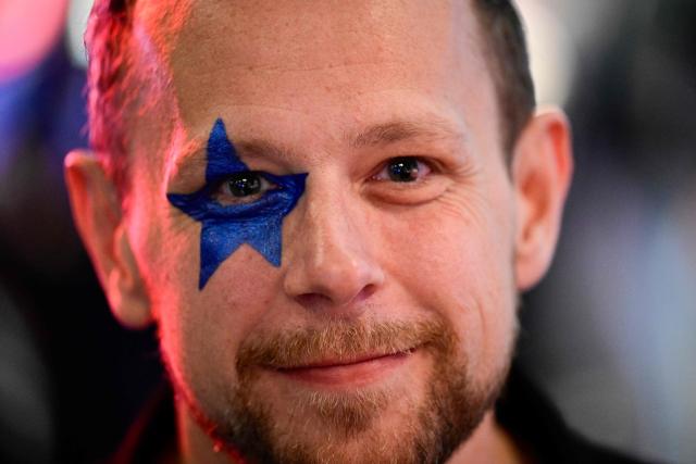 A fan of Austrian singer Benjamin Gedeon, aka Cosmo and representing Austria with the song 'Tanzschein' poses ahead the final of the Eurovision Song Contest 2026 (ESC) at Wiener Stadthalle in Vienna, Austria on May 16, 2026. (Photo by Tobias SCHWARZ / AFP)