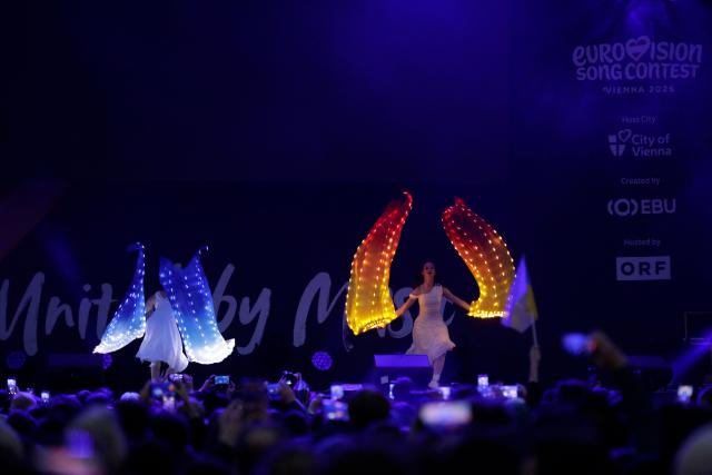 Dancers perform on the stage as spectators gather at the fan area to watch prior to the start of the Eurovision Song Contest 2026 (ESC) final outside the City Hall in Vienna, Austria on May 16, 2026. (Photo by Alex HALADA / AFP)