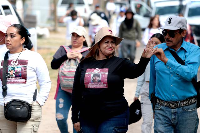 Cecilia Flores (C), activist and founding member of the Madres Buscadoras de Sonora collective, walks with members of the Madres Buscadoras de Jalisco collective before entering the site of the Las Pintitas mass grave in El Salto, Jalisco state, Mexico, on May 16, 2026. (Photo by ULISES RUIZ / AFP)