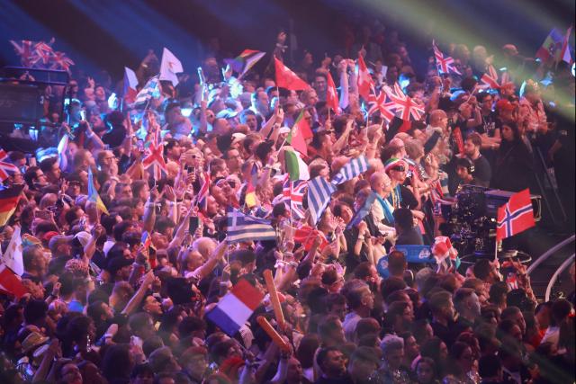 Fans wave flags during the final of the Eurovision Song Contest 2026 (ESC) at Wiener Stadthalle in Vienna, Austria on May 16, 2026. (Photo by Radek MICA / AFP)