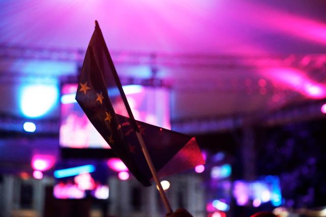 Spectators raise a flag of European Union (EU) as fans gather at the fan area to watch the final of the Eurovision Song Contest 2026 (ESC) outside the City Hall in Vienna, Austria on May 16, 2026. (Photo by Alex HALADA / AFP)
