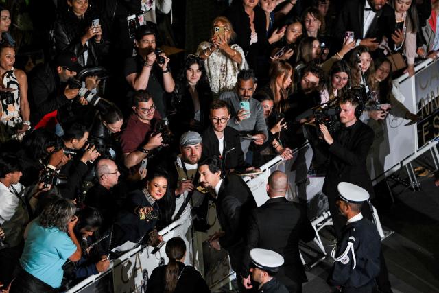 US actor Adam Driver takes selfies with fans as he arrives for the screening of the film "Paper Tiger" at the 79th edition of the Cannes Film Festival in Cannes, southern France on May 16, 2026. (Photo by Olivier CHASSIGNOLE / AFP)