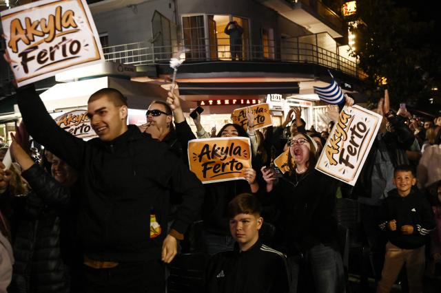 Supporters react as they watch on a giant screen the live performance of Greek singer Akylas Mytilinaios, known as Akylas, representing Greece with the song "Ferto" ("Bring It") in the final of the Eurovision Song Contest 2026 at the Wiener Stadthalle in Vienna, in Serres, northern Greece on May 16, 2026. (Photo by SAKIS MITROLIDIS / AFP)