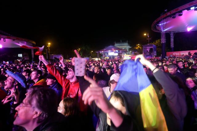Spectators and fans react as they are gathered at the fan area to watch the final of the Eurovision Song Contest 2026 (ESC) outside the City Hall in Vienna, Austria on May 16, 2026. (Photo by Alex HALADA / AFP)