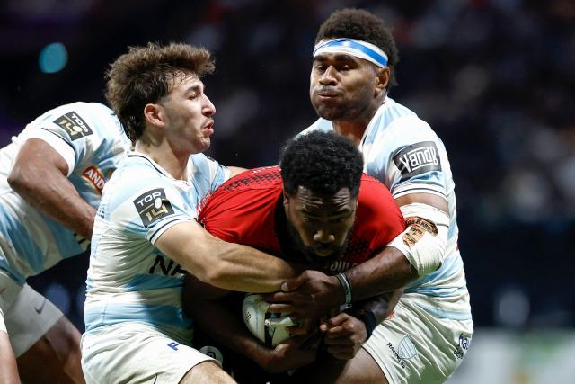 Toulon's Fijian centre Setariki Tuicuvu (C) is tackled by Racing 92' French scrum-half Leo Carbonneau (L) and Racing 92' Fijian winger Vinaya Habosi (R) during the French Top14 rugby union match between Racing 92 and Rugby Club Toulonnais (Toulon) at the Paris La Defense Arena in Nanterre, on the outskirts of Paris on May 16, 2026. (Photo by Kenzo TRIBOUILLARD / AFP)