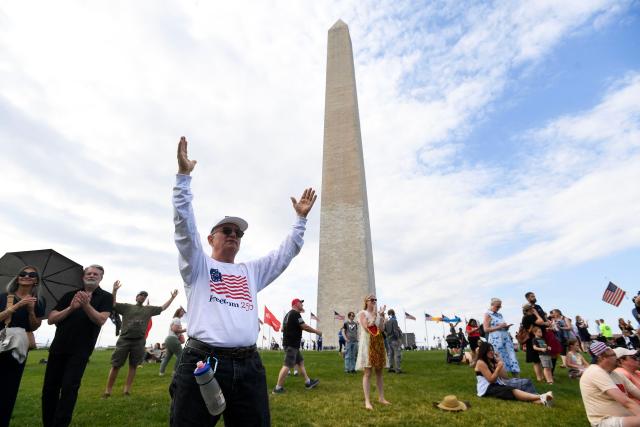 Christian worshipers raise their hands as faith leaders pray during the Roots of Revival event at the Washington Monument, held a day ahead of "Rededicate 250: A National Jubilee of Prayer, Praise and Thanksgiving" in Washington, DC, on May 16, 2026. (Photo by Matthew Hatcher / AFP)