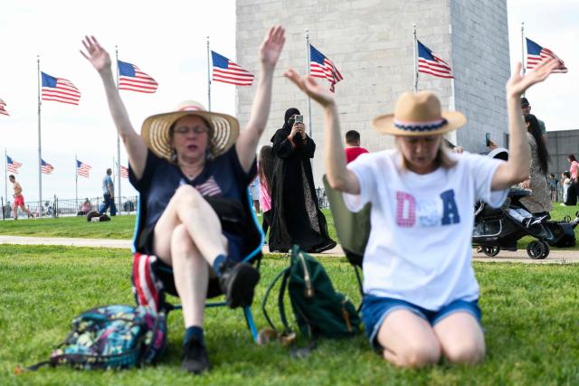 Christian worshipers raise their hands as faith leaders pray during the Roots of Revival event at the Washington Monument, held a day ahead of "Rededicate 250: A National Jubilee of Prayer, Praise and Thanksgiving" in Washington, DC, on May 16, 2026. (Photo by Matthew Hatcher / AFP)