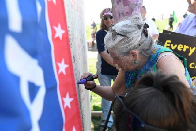 Christian worshipers sign a prayer wall as they attend the Roots of Revival event at the Washington Monument, held a day ahead of "Rededicate 250: A National Jubilee of Prayer, Praise and Thanksgiving" in Washington, DC, on May 16, 2026. (Photo by Matthew Hatcher / AFP)