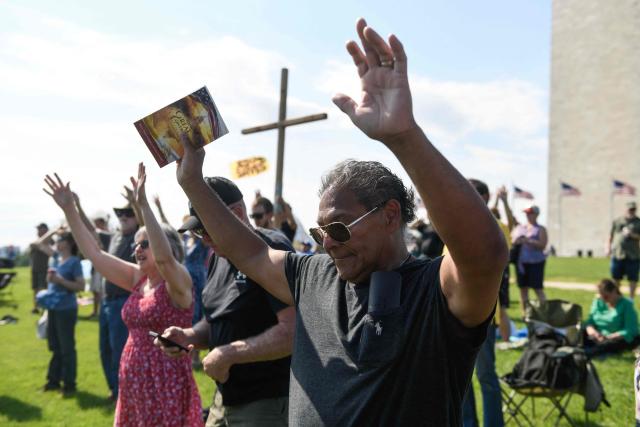 Christian worshipers raise their hands as faith leaders pray during the Roots of Revival event at the Washington Monument, held a day ahead of "Rededicate 250: A National Jubilee of Prayer, Praise and Thanksgiving" in Washington, DC, on May 16, 2026. (Photo by Matthew Hatcher / AFP)