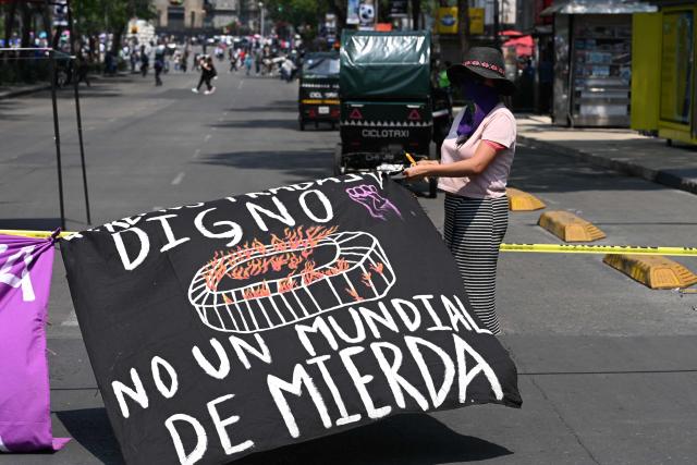 An activist from a feminist collective holds a sign protesting against the upcoming FIFA World Cup in Mexico City on May 16, 2026. (Photo by Yuri CORTEZ / AFP)