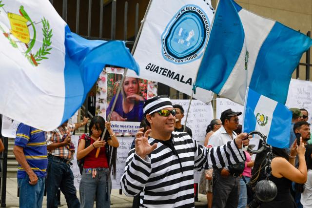 People attend a rally to celebrate the end of the term of Attorney General Consuelo Porras on the outskirts of the Public Ministry headquarters in Guatemala City on May 16, 2026. The Attorney General of Guatemala, Consuelo Porras, sanctioned by 40 countries and considered the most powerful woman in the country, is leaving office after eight years, which nevertheless does not dispel the shadow of corruption over the justice system. (Photo by Johan ORDONEZ / AFP)