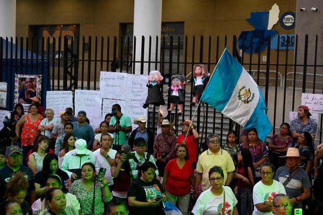 People attend a rally to celebrate the end of the term of Attorney General Consuelo Porras on the outskirts of the Public Ministry headquarters in Guatemala City on May 16, 2026. The Attorney General of Guatemala, Consuelo Porras, sanctioned by 40 countries and considered the most powerful woman in the country, is leaving office after eight years, which nevertheless does not dispel the shadow of corruption over the justice system. (Photo by Johan ORDONEZ / AFP)