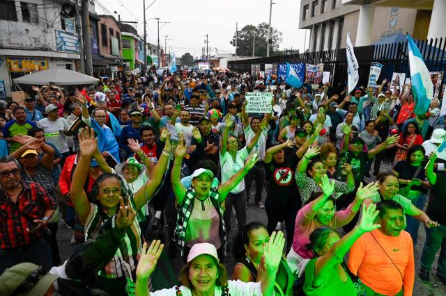 People attend a rally to celebrate the end of the term of Attorney General Consuelo Porras on the outskirts of the Public Ministry headquarters in Guatemala City on May 16, 2026. The Attorney General of Guatemala, Consuelo Porras, sanctioned by 40 countries and considered the most powerful woman in the country, is leaving office after eight years, which nevertheless does not dispel the shadow of corruption over the justice system. (Photo by Johan ORDONEZ / AFP)