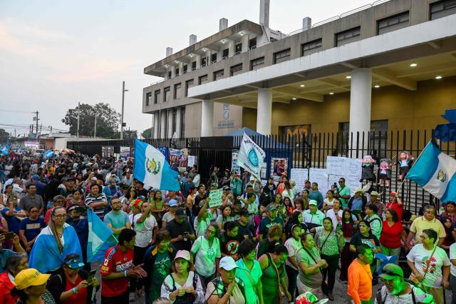 People attend a rally to celebrate the end of the term of Attorney General Consuelo Porras on the outskirts of the Public Ministry headquarters in Guatemala City on May 16, 2026. The Attorney General of Guatemala, Consuelo Porras, sanctioned by 40 countries and considered the most powerful woman in the country, is leaving office after eight years, which nevertheless does not dispel the shadow of corruption over the justice system. (Photo by Johan ORDONEZ / AFP)