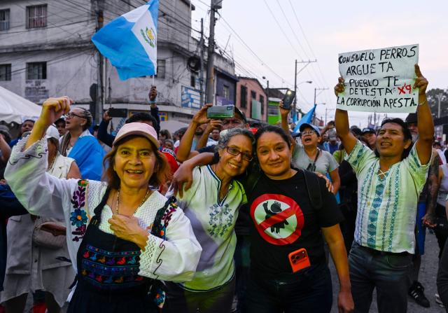 People attend a rally to celebrate the end of the term of Attorney General Consuelo Porras on the outskirts of the Public Ministry headquarters in Guatemala City on May 16, 2026. The Attorney General of Guatemala, Consuelo Porras, sanctioned by 40 countries and considered the most powerful woman in the country, is leaving office after eight years, which nevertheless does not dispel the shadow of corruption over the justice system. (Photo by Johan ORDONEZ / AFP)