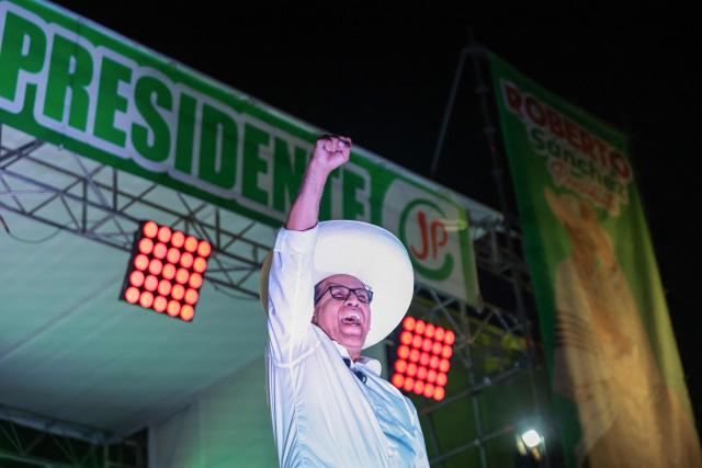 Peru's presidential candidate Roberto Sanchez, of the Juntos por el Peru party, waves to supporters during a rally in Lima on May 16, 2026. Left-wing candidate Roberto Sanchez has qualified for the runoff of Peru's presidential election and will face right-wing candidate Keiko Fujimori in June. (Photo by Connie FRANCE / AFP)