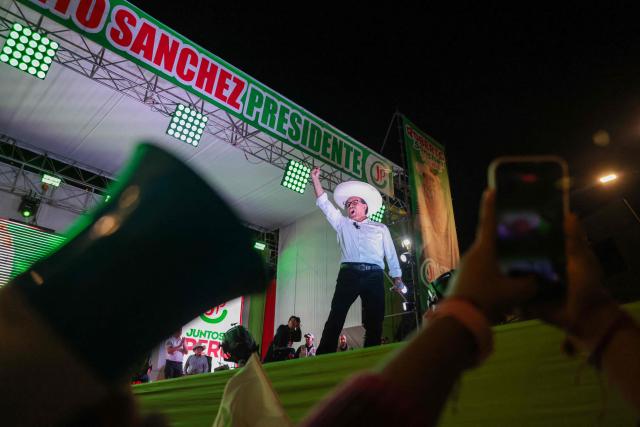 Peru's presidential candidate Roberto Sanchez, of the Juntos por el Peru party, waves to supporters during a rally in Lima on May 16, 2026. Left-wing candidate Roberto Sanchez has qualified for the runoff of Peru's presidential election and will face right-wing candidate Keiko Fujimori in June. (Photo by Connie FRANCE / AFP)