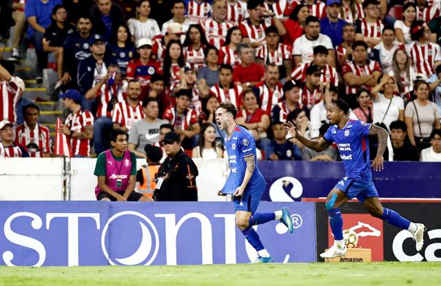 Cruz Azul's Argentine midfielder #08 Agustin Palavecino (L) celebrates with teammate Colombian defender #04 Willer Ditta after scoring his team's second goal during the Liga MX Clausura semifinal second-leg football match between Guadalajara and Cruz Azul at Jalisco stadium in Guadalajara, Jalisco state, Mexico on May 16, 2026. (Photo by Ulises Ruiz / AFP)