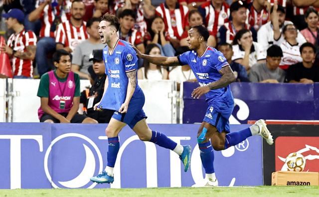 Cruz Azul's Argentine midfielder #08 Agustin Palavecino (L) celebrates with teammate Colombian defender #04 Willer Ditta after scoring his team's second goal during the Liga MX Clausura semifinal second-leg football match between Guadalajara and Cruz Azul at Jalisco stadium in Guadalajara, Jalisco state, Mexico on May 16, 2026. (Photo by Ulises Ruiz / AFP)