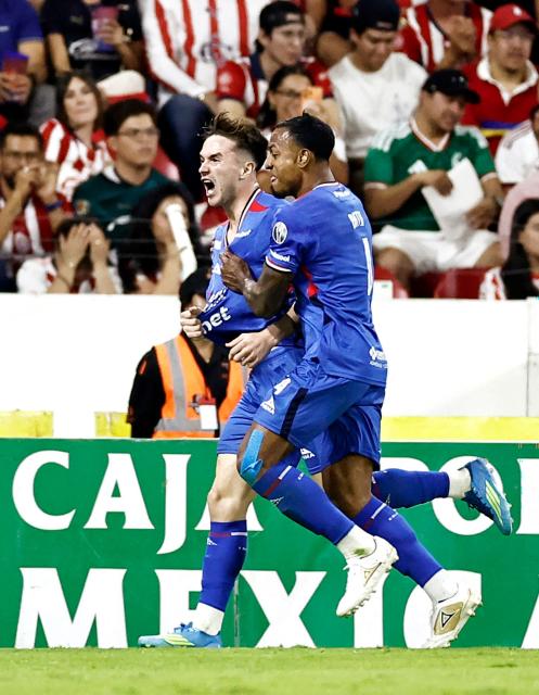 Cruz Azul's Argentine midfielder #08 Agustin Palavecino (L) celebrates with teammate Colombian defender #04 Willer Ditta after scoring his team's second goal during the Liga MX Clausura semifinal second-leg football match between Guadalajara and Cruz Azul at Jalisco stadium in Guadalajara, Jalisco state, Mexico on May 16, 2026. (Photo by Ulises Ruiz / AFP)
