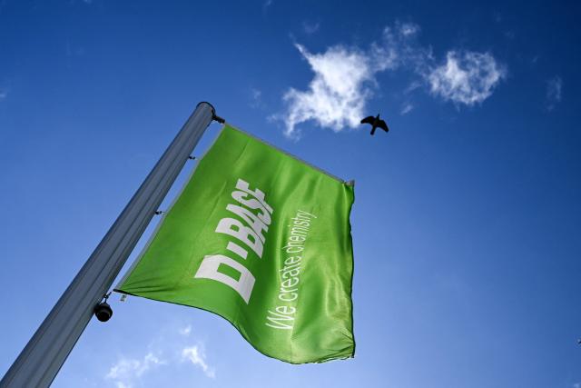 Flag with the logo of German chemical giant BASF is pictured in front of BASF headquarters in Ludwigshafen, western Germany, on April 20, 2026. Germany's industrial decline is taking a painful toll on communities that have long relied on local manufacturing titans for jobs, prosperity and a sense of a secure future. (Photo by Kirill KUDRYAVTSEV / AFP) / TO GO WITH AFP STORY BY SAM REEVES