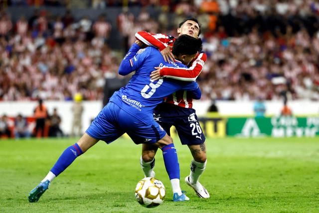 Cruz Azul's defender #03 Omar Campos and Guadalajara's forward #26 Hugo Camberos fight for the ball during the Liga MX Clausura semifinal second-leg football match between Guadalajara and Cruz Azul at Jalisco stadium in Guadalajara, Jalisco state, Mexico on May 16, 2026. (Photo by ULISES RUIZ / AFP)