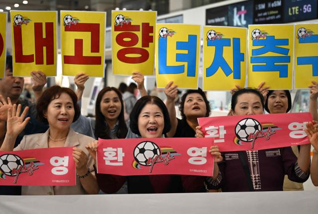South Korean activists hold banners welcoming North Korea's Naegohyang Women's FC as they wait for the North Korean team's arrival at Incheon International Airport in Incheon on May 17, 2026, ahead of the Women's Asian Champions League semifinal match between South Korea's Suwon FC Women and North Korea's Naegohyang Women's FC. (Photo by Jung Yeon-je / AFP)