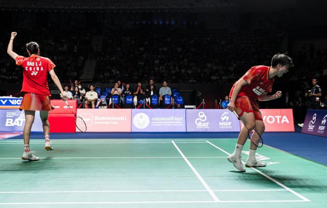 China's Cao Zihan (R) and China's Bao Lijing (L) celebrate a point against Japan's Kie Nakanishi and Japan's Rin Iwanaga during their women's doubles final match at the Thailand Open badminton tournament in Bangkok on May 17, 2026.  (Photo by chanakarn LAOSARAKHAM / AFP)