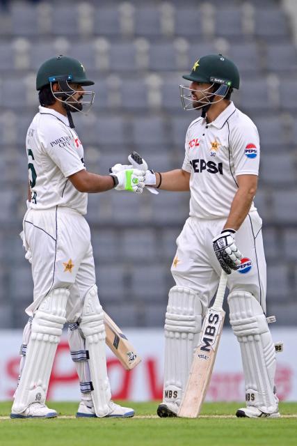 Pakistan’s Babar Azam (L) celebrates with Salman Agha after scoring a half-century (50 runs) during the second day of the second Test cricket match between Bangladesh and Pakistan at the Sylhet International Cricket Stadium in Sylhet on May 17, 2026. (Photo by Munir UZ ZAMAN / AFP)