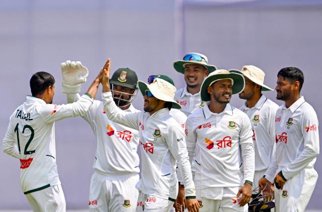 Bangladesh’s Taijul Islam (L) celebrates with teammates after taking the wicket of Pakistan’s Salman Agha during the second day of the second Test cricket match between Bangladesh and Pakistan at the Sylhet International Cricket Stadium in Sylhet on May 17, 2026. (Photo by Munir UZ ZAMAN / AFP)