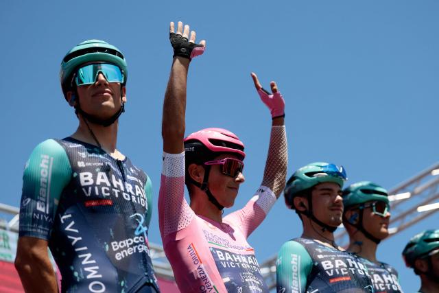Bahrain - Victorious Portuguese rider Afonso Eulalio, wearing the overall leader's pink jersey (Maglia Rosa), waves on the signature podium before the 9th stage of the Giro d'Italia 2026 - Tour of Italy cycling race between Cervia and Corno alle Scale, central Italy on May 17, 2026. (Photo by Luca Bettini / AFP)
