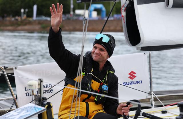 French skipper Loïs Berrehar waves from his boat "Banque Populaire" before the start of the Solitaire du Figaro, a single-handed multi-stage sailing race created in 1970 by Jean-Louis Guillemard and Jean-Michel Barrault, in Perros-Guirrec, western France,  May 17, 2026. (Photo by Fred TANNEAU / AFP)
