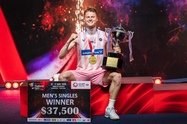 Denmark's Anders Antonsen celebrates with the trophy after his victory against Thailand's Kunlavut Vitidsarn in their men's singles final match at the Thailand Open badminton tournament in Bangkok on May 17, 2026. (Photo by chanakarn LAOSARAKHAM / AFP)