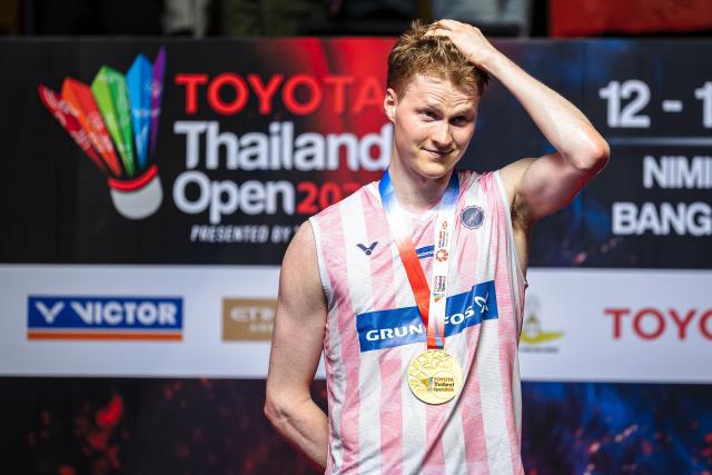 Denmark's Anders Antonsen celebrates with his medal on the podium after his victory against Thailand's Kunlavut Vitidsarn in their men's singles final match at the Thailand Open badminton tournament in Bangkok on May 17, 2026. (Photo by chanakarn LAOSARAKHAM / AFP)
