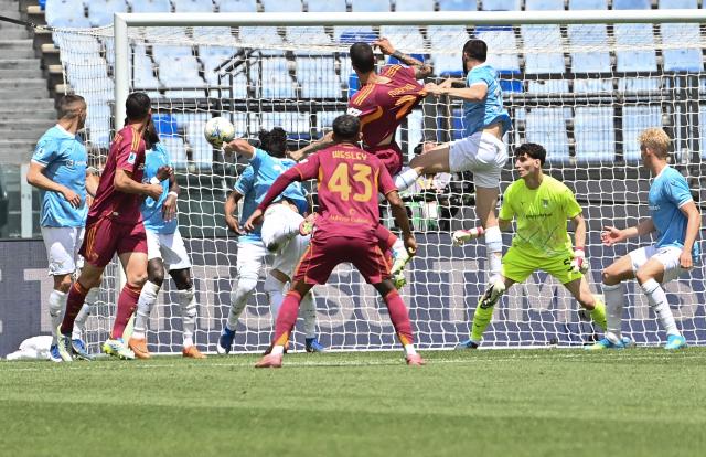 Roma's Italian defender #23 Gianluca Mancini (C, up) heads the ball and scores his team's first goal during the Italian Serie A football match between Roma and Lazio at Olympic stadium in Rome on May 17, 2026. (Photo by Isabella BONOTTO / AFP)