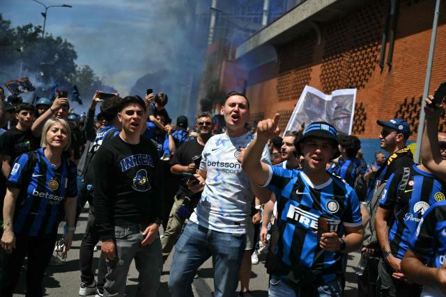 Inter Milan's supporters cheer during the arrival of the bus transporting players before the Italian Serie A football match between Inter Milan and Hellas Verona at San Siro stadium in Milan, on May 17, 2026. (Photo by Marco BERTORELLO / AFP)