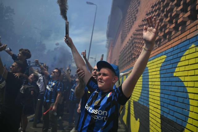 Inter Milan's supporters cheer during the arrival of the bus transporting players before the Italian Serie A football match between Inter Milan and Hellas Verona at San Siro stadium in Milan, on May 17, 2026. (Photo by Marco BERTORELLO / AFP)