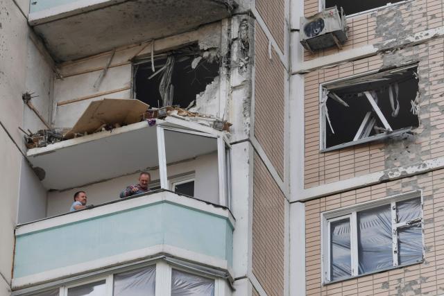 Local residents inspect a damaged balcony in a residential building following an air attack in Krasnogorsk, Moscow region on May 17, 2026, amid the ongoing Russian-Ukrainian conflict. A wave of almost 600 Ukrainian drones attacked Russia overnight killing four people, authorities said on May 17, 2026, as Ukraine's President Volodymyr Zelensky called the barrage an 'entirely justified' retribution for Moscow's own pummelling of Ukraine. (Photo by TATYANA MAKEYEVA / AFP)