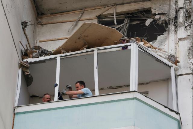 Local inspect a damaged balcony in a residential building following an air attack in Krasnogorsk, Moscow region on May 17, 2026, amid the ongoing Russian-Ukrainian conflict. A wave of almost 600 Ukrainian drones attacked Russia overnight killing four people, authorities said on May 17, 2026, as Ukraine's President Volodymyr Zelensky called the barrage an 'entirely justified' retribution for Moscow's own pummelling of Ukraine. (Photo by TATYANA MAKEYEVA / AFP)