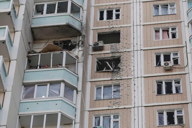 Local residents inspect a damaged balcony in a residential building following an air attack in Krasnogorsk, Moscow region on May 17, 2026, amid the ongoing Russian-Ukrainian conflict. A wave of almost 600 Ukrainian drones attacked Russia overnight killing four people, authorities said on May 17, 2026, as Ukraine's President Volodymyr Zelensky called the barrage an 'entirely justified' retribution for Moscow's own pummelling of Ukraine. (Photo by TATYANA MAKEYEVA / AFP)